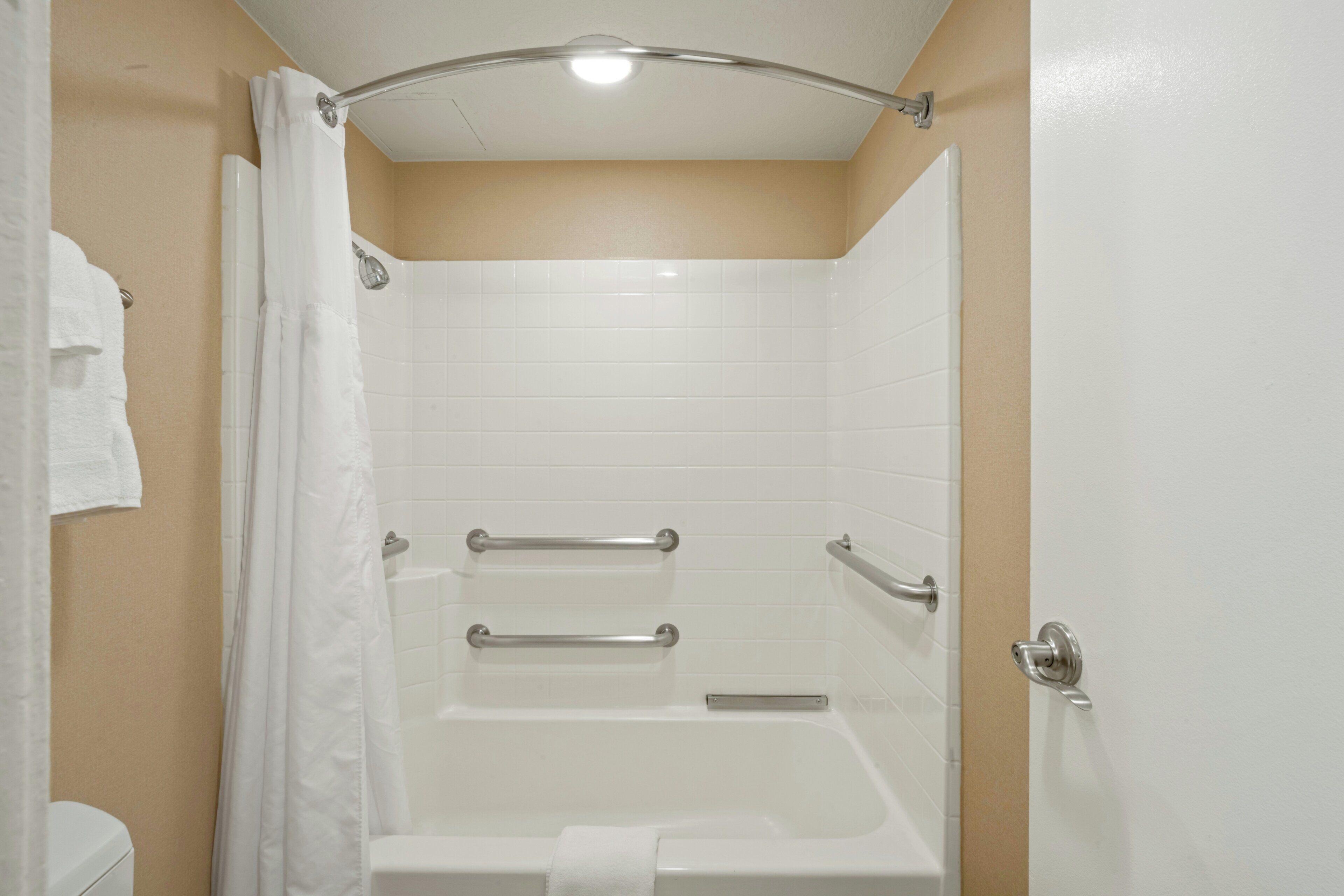 Un baño con bañera, cortina de ducha y toallero.