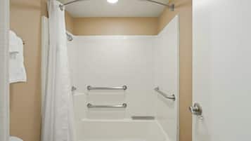Un baño con bañera, cortina de ducha y toallero.