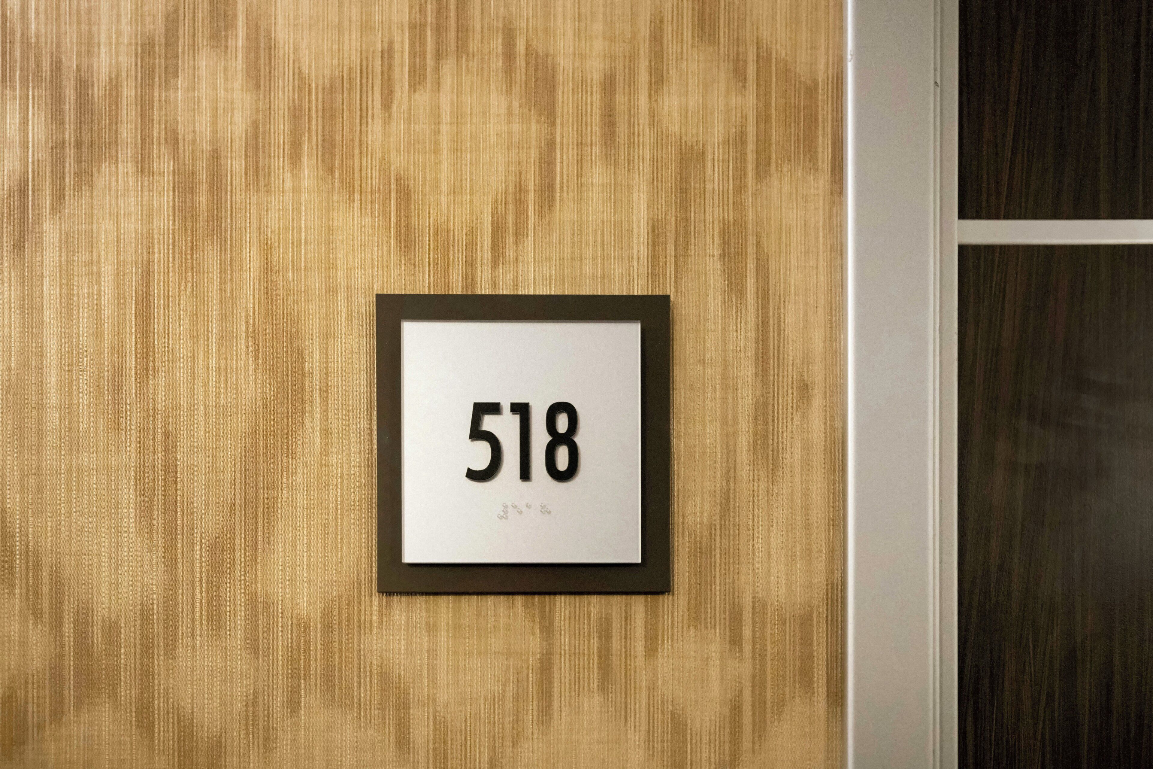 Een lijst met het nummer '518' op een ruwe muur.