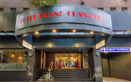The entrance to the Hotel Grand Chancellor with a public parking sign.