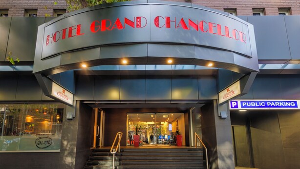 La entrada al Hotel Grand Chancellor con un letrero de estacionamiento público.