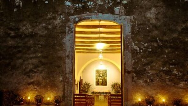 A stone pathway leading to a rustic building entrance with a warm light inside. - Hacienda Chichen Resort & Yaxkin Spa (Chichen Itza)
