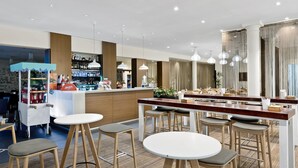 Un área de bar moderna con taburetes, una barra y una variedad de botellas.