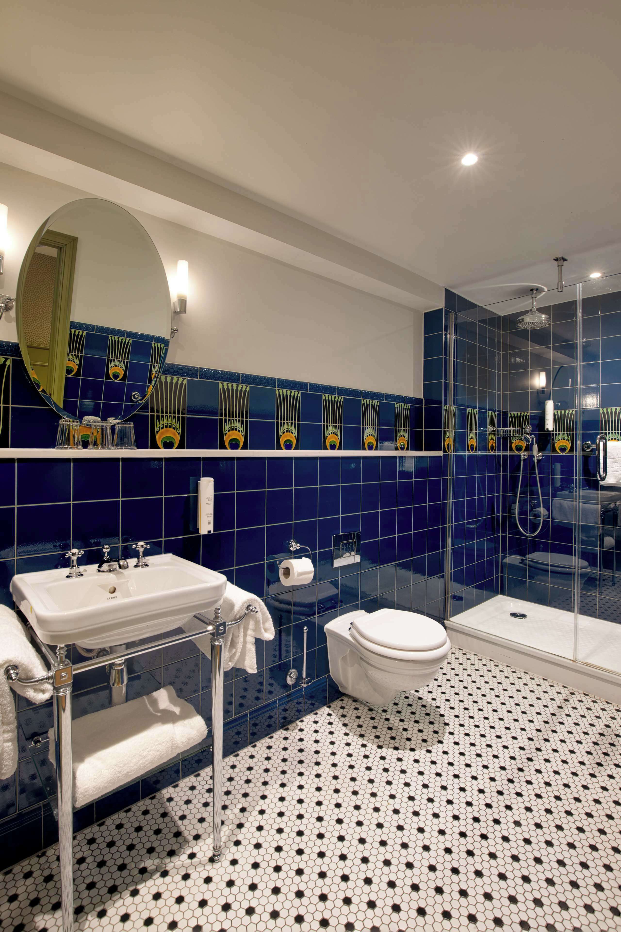 Et badeværelse med hvid vask, toilet og glasafskærmet brusebad.