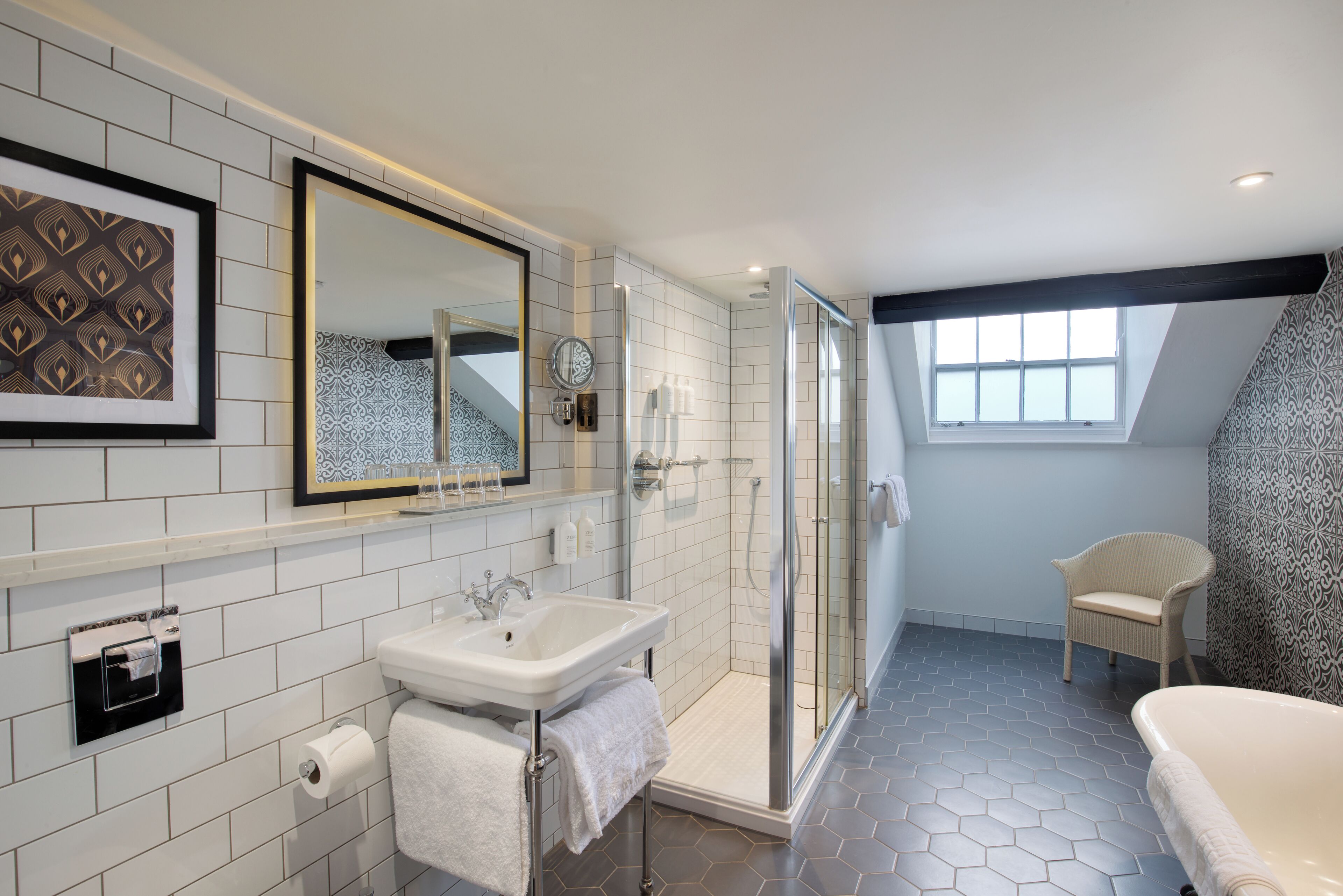 Une salle de bain moderne avec une douche à parois de verre, un lavabo blanc et une baignoire.