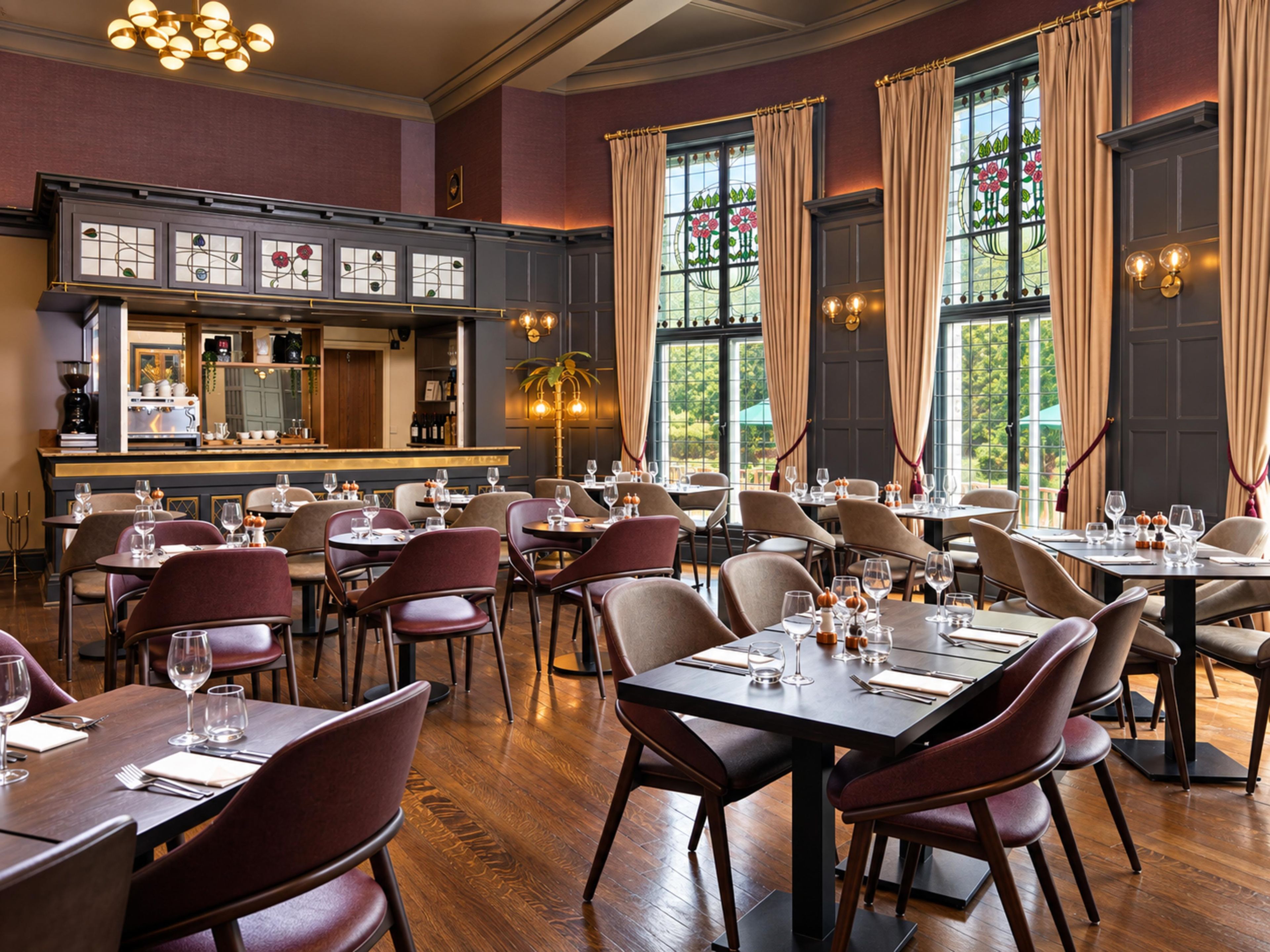 A restaurant with multiple dining tables and chairs, a bar area, and large windows with curtains.