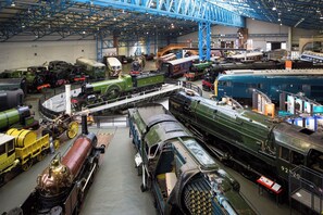 A large indoor train museum with multiple vintage trains on display. - Elmbank York, Tapestry Collection by Hilton (York)