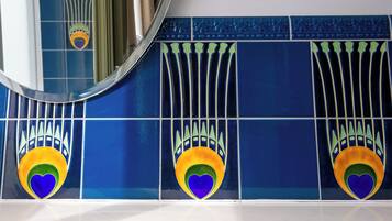 A bathroom with blue tiles and a mirror.