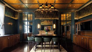 A spacious kitchen with wooden cabinets, a large island with bar stools, and a chandelier. - Elmbank York, Tapestry Collection by Hilton (York)