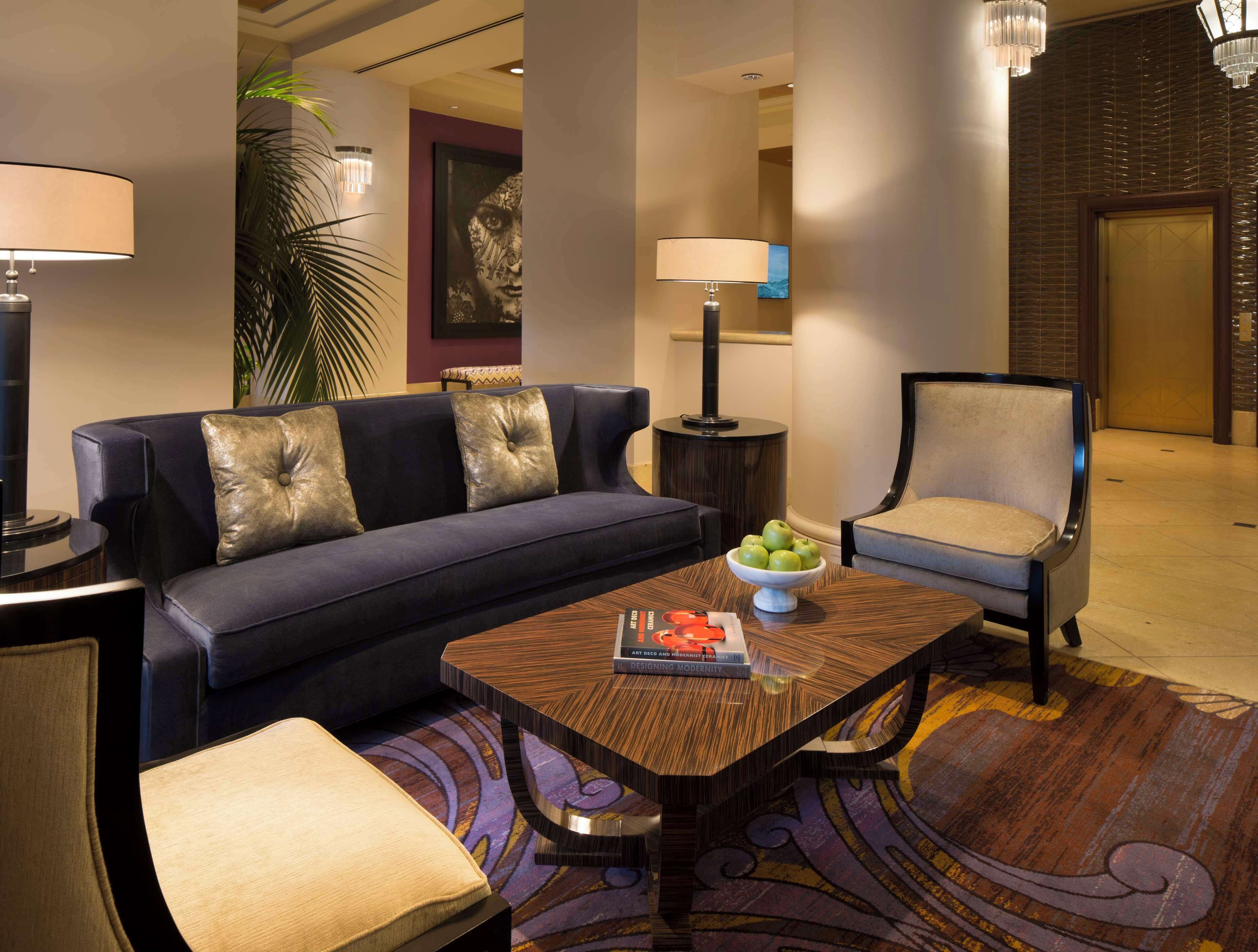 A modern hotel lobby with a sofa, armchair, and coffee table.