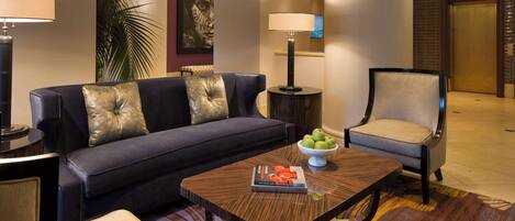 A modern hotel lobby with a sofa, armchair, and coffee table.