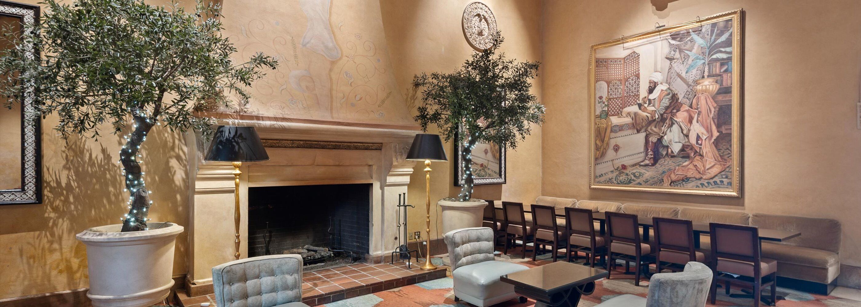A lobby with a fireplace, seating area, and a large painting.