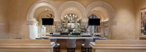 A bar area with a high ceiling, arched alcoves, and a central chandelier. - Hotel De Anza by IHG (San Jose)