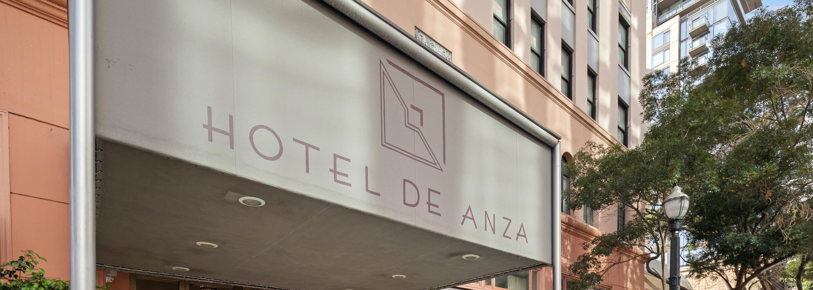 A hotel sign with the name "HOTEL DE ANZA" and a logo.