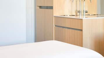 Un baño moderno con tocador de madera, lavabo y espejo.