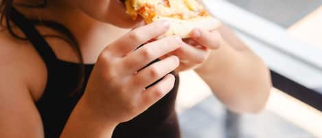 A person holding a slice of pizza.