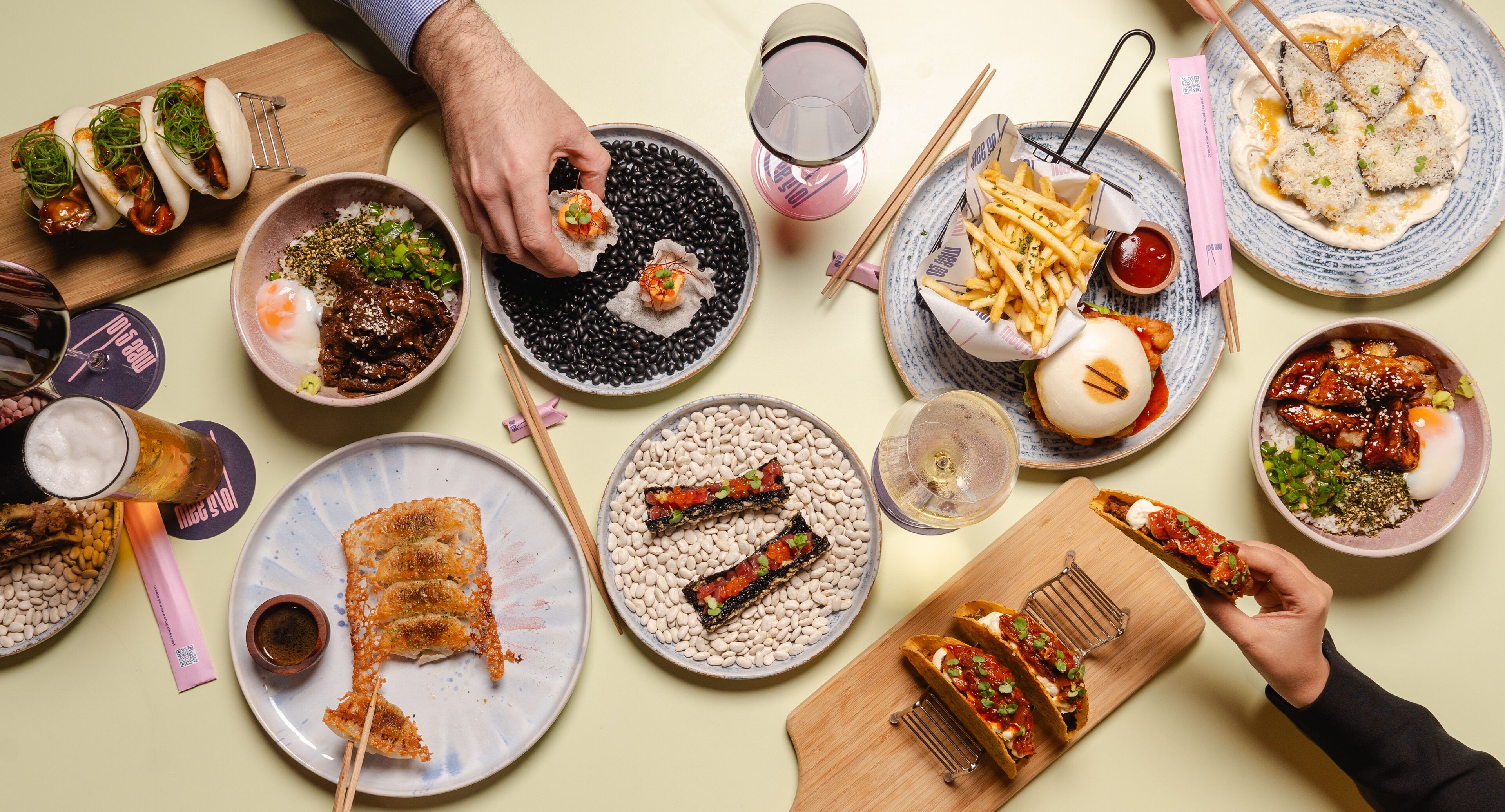 On peut voir une variété de plats présentés sur des assiettes, notamment des sushis, des aliments frits et un bol contenant un œuf au plat.
