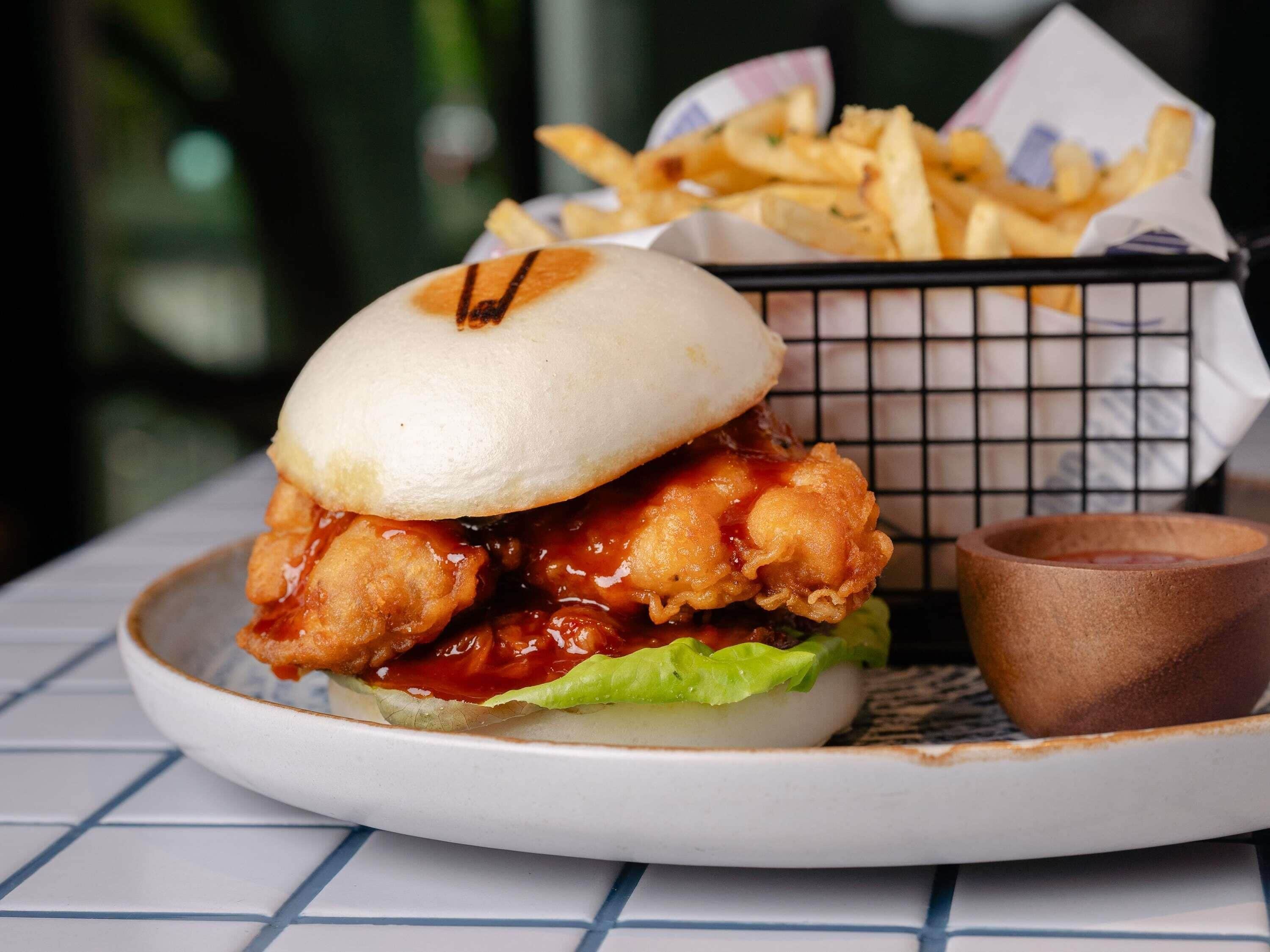 Un sandwich au poulet, accompagné de frites et de ketchup, servi sur une assiette.