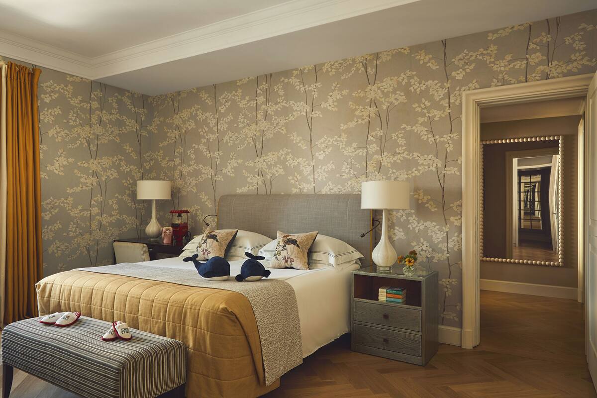 A bedroom with a bed, nightstands, a bench, and a mirror.