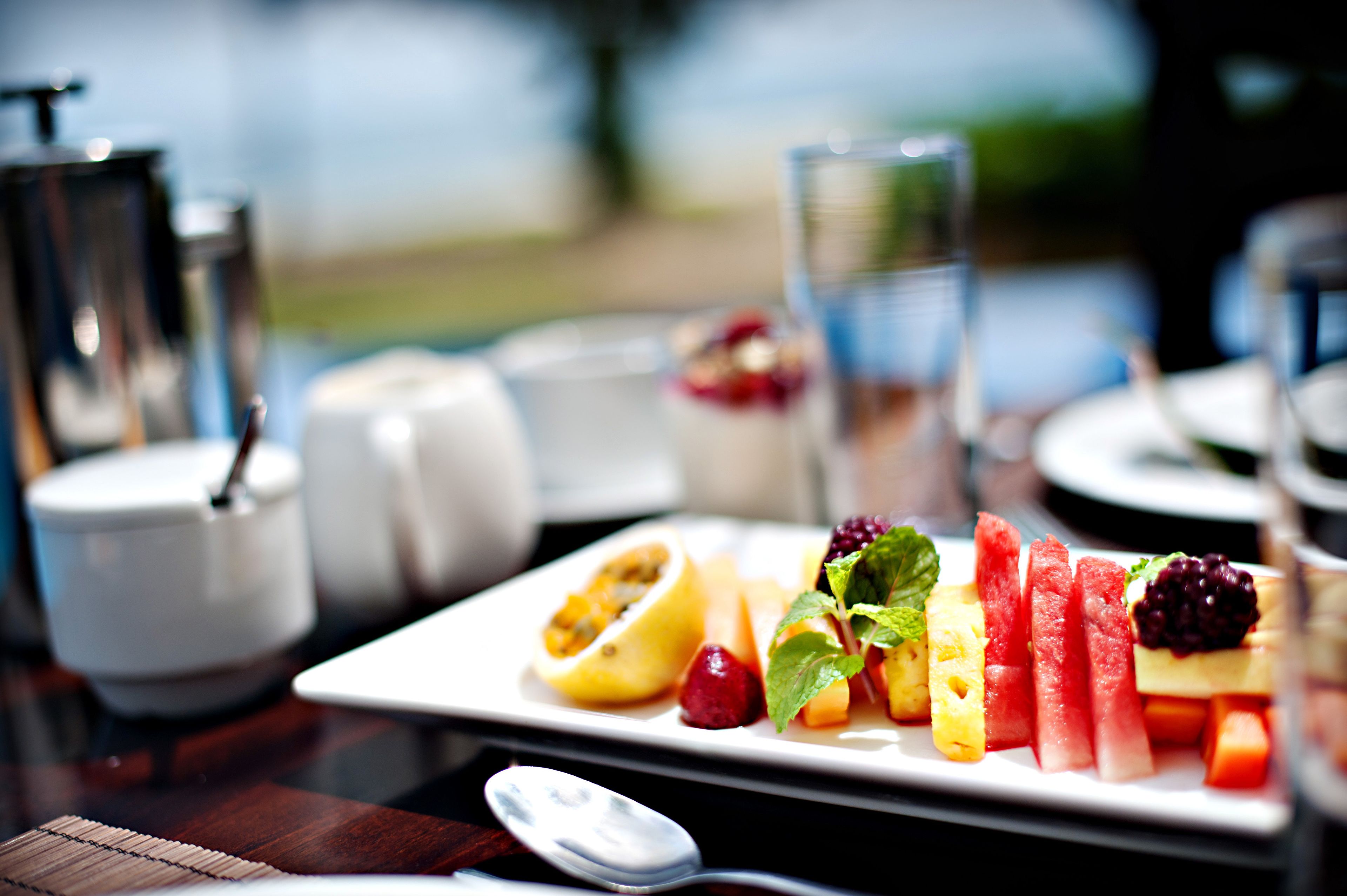 A breakfast setting with a variety of fruits and a glass of water on a table.