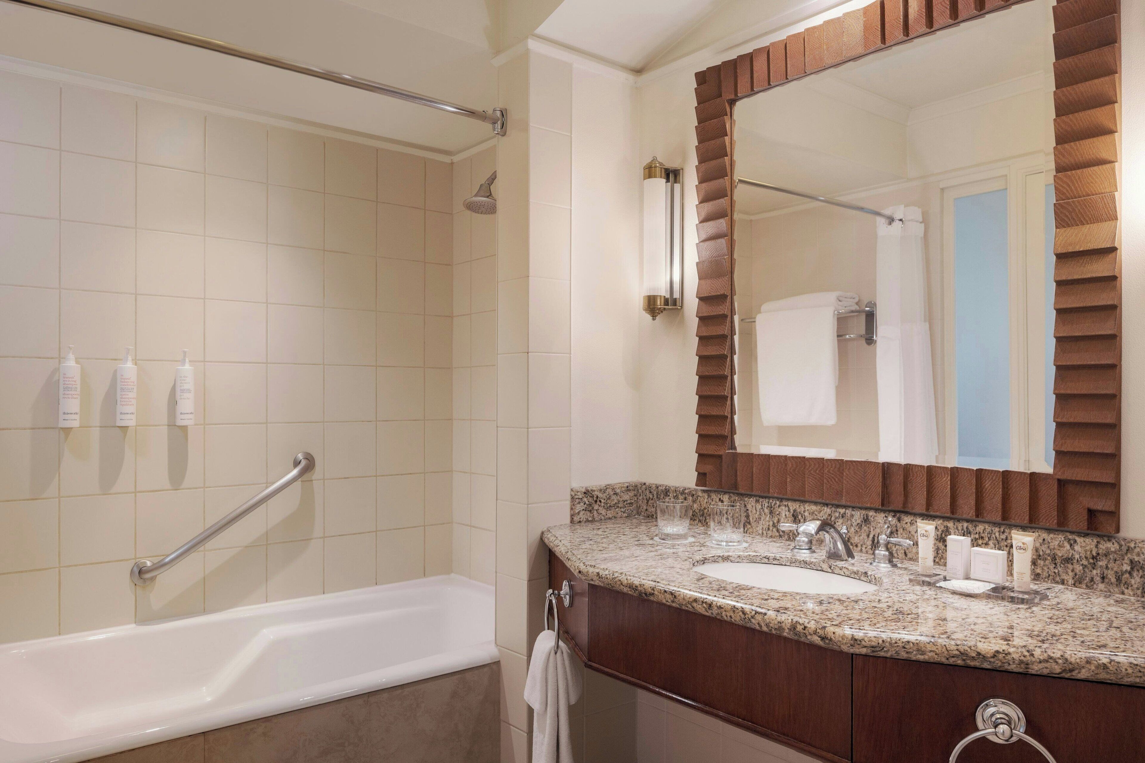 Une salle de bain avec une baignoire, une douche, un meuble-lavabo et un miroir.