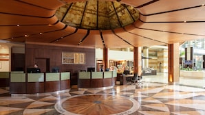 A lobby with a central circular design, reception desks, and a large ceiling structure. - Santiago Marriott Hotel (Santiago)