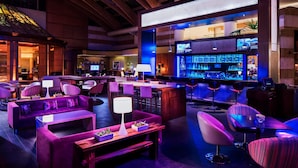 A bar area with seating and a bar counter, featuring a modern design with purple and blue lighting. - Santiago Marriott Hotel (Santiago)