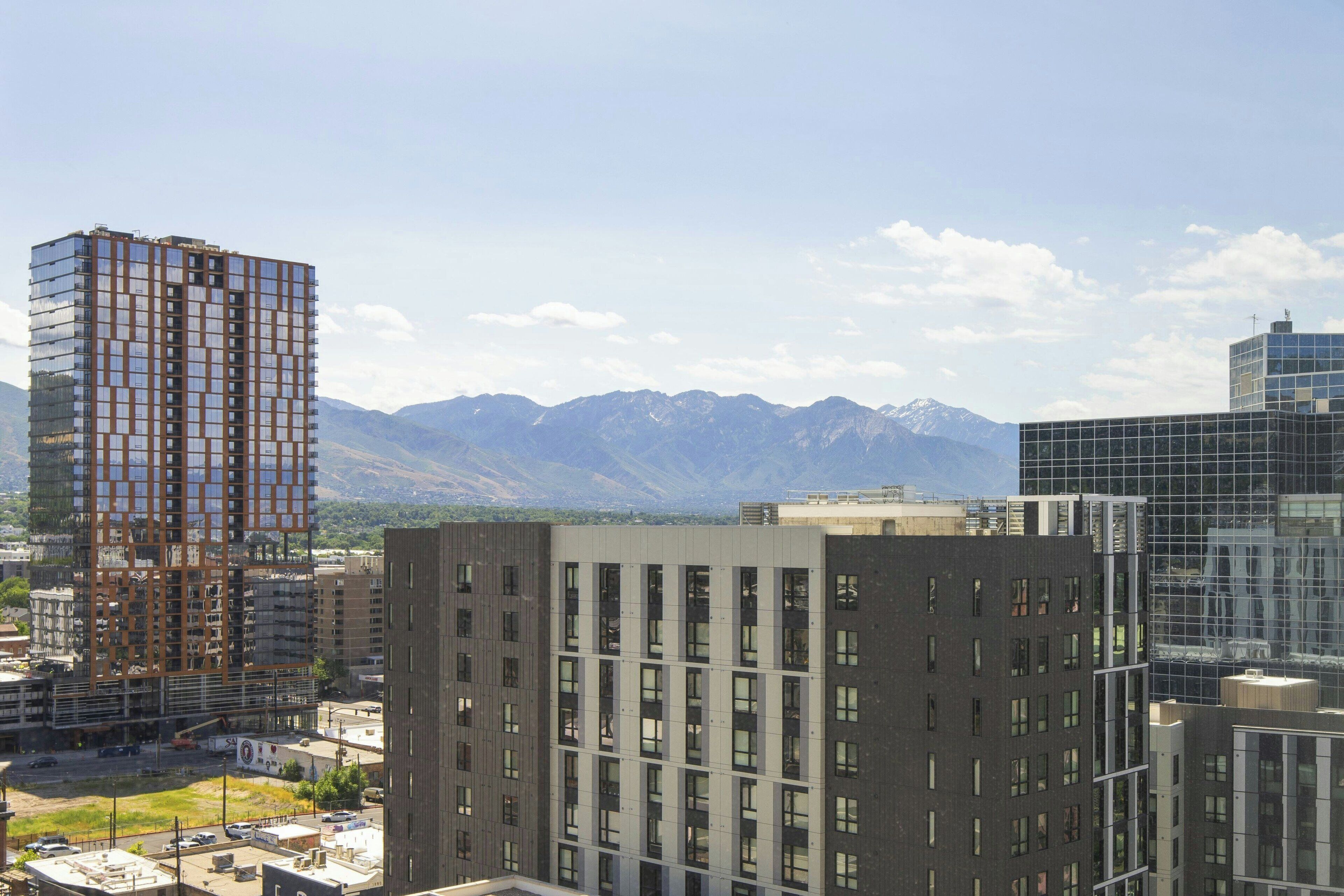 A modern urban area with high-rise buildings and mountains in the background.