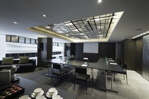 Meetings and presentations take place around a long, rectangular table in this modern conference space.