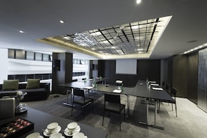 Meetings and presentations take place around a long, rectangular table in this modern conference space.