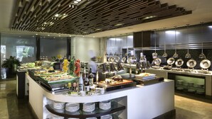 A buffet area with a variety of food items, plates, and serving utensils. - Marco Polo Davao (Davao)