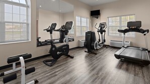A gym with treadmills, elliptical machines, and weight benches. - Americas Best Value Inn & Suites Racine (Mount Pleasant)