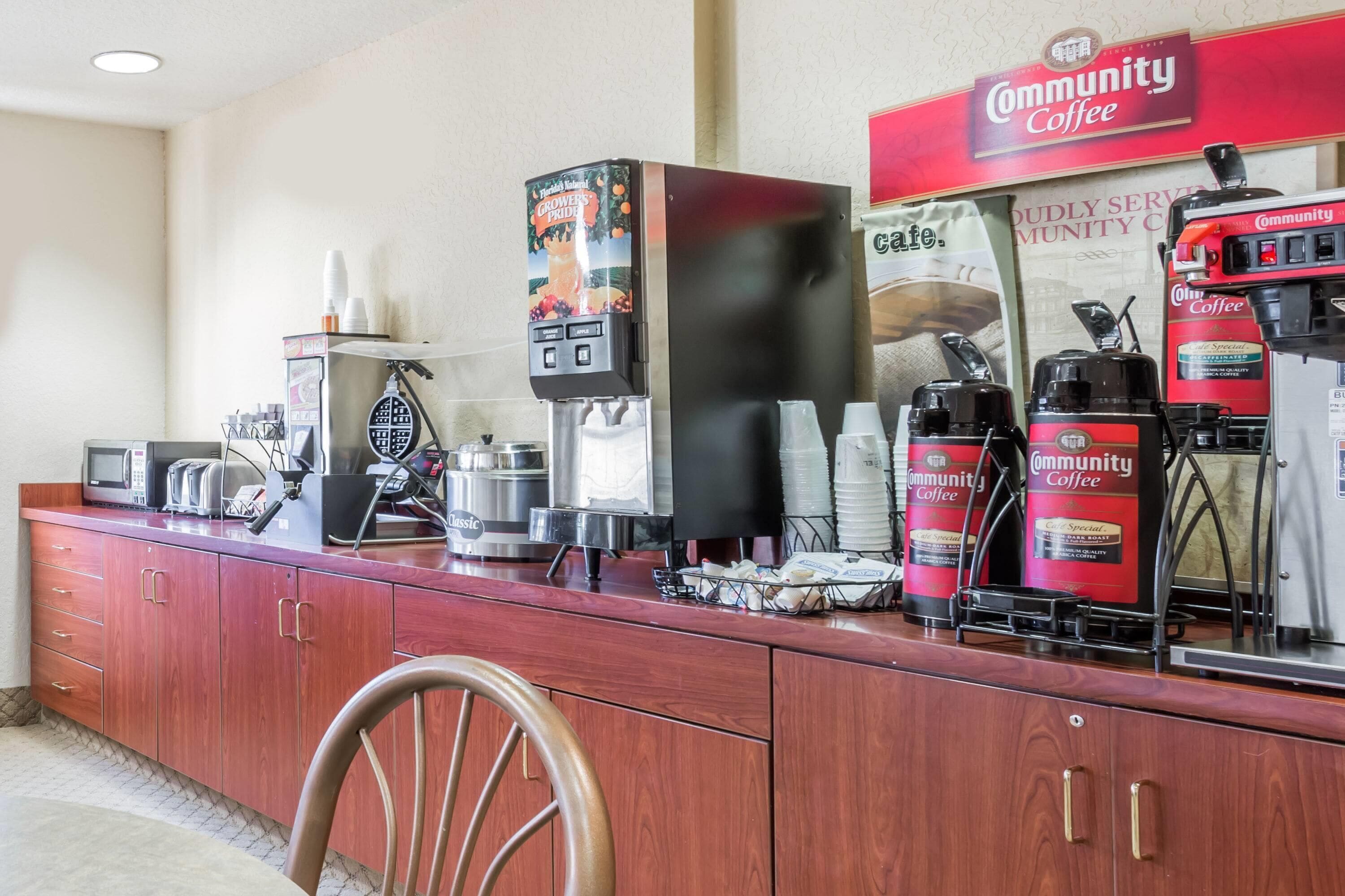 A coffee station with multiple coffee dispensers, a microwave, and a toaster.