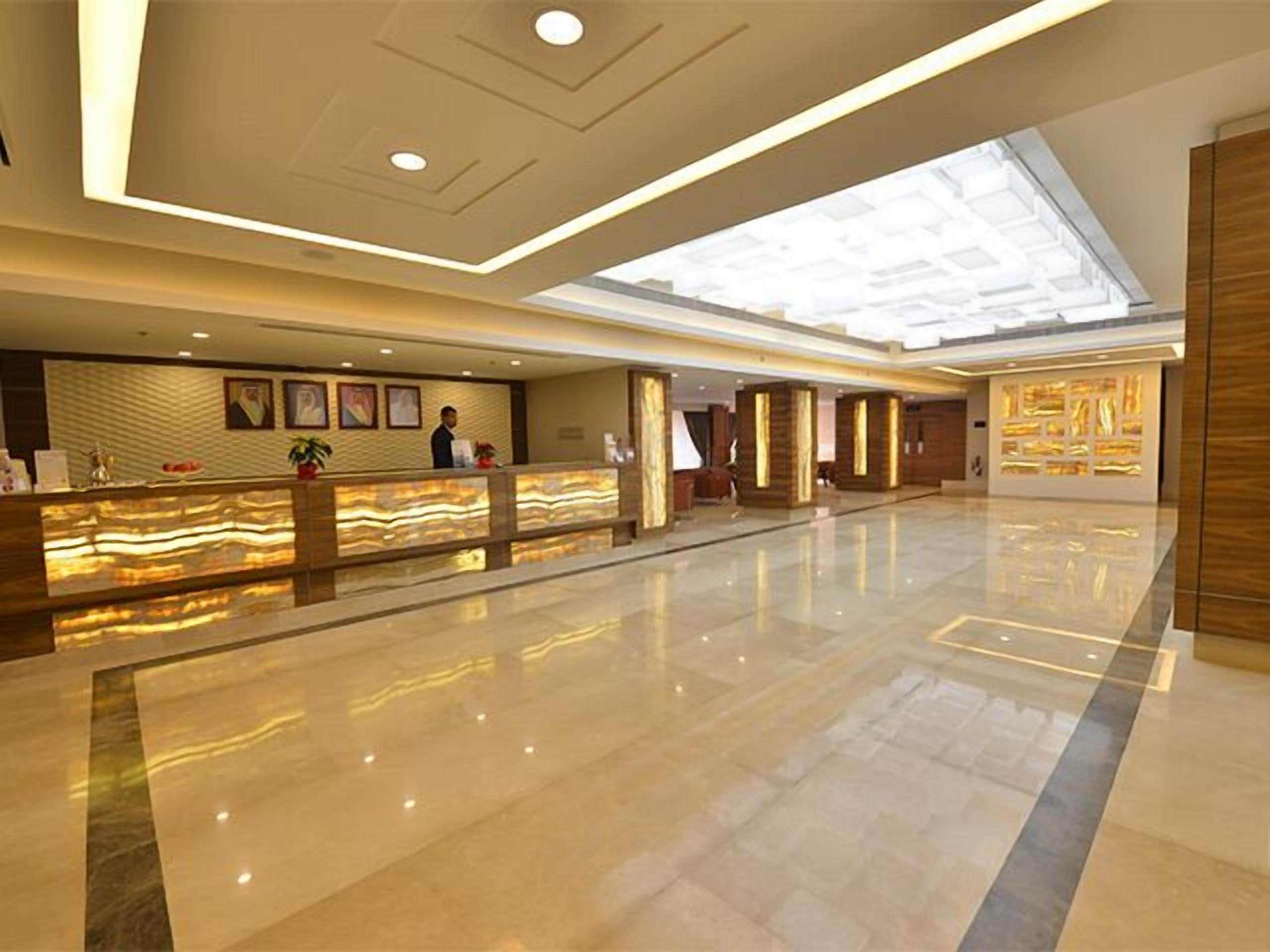 A spacious lobby with a reception desk, a large skylight, and a modern design.