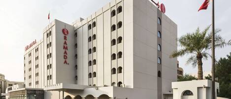Un moderno edificio de hotel con un llamativo letrero de 'RAMADA' en la fachada.