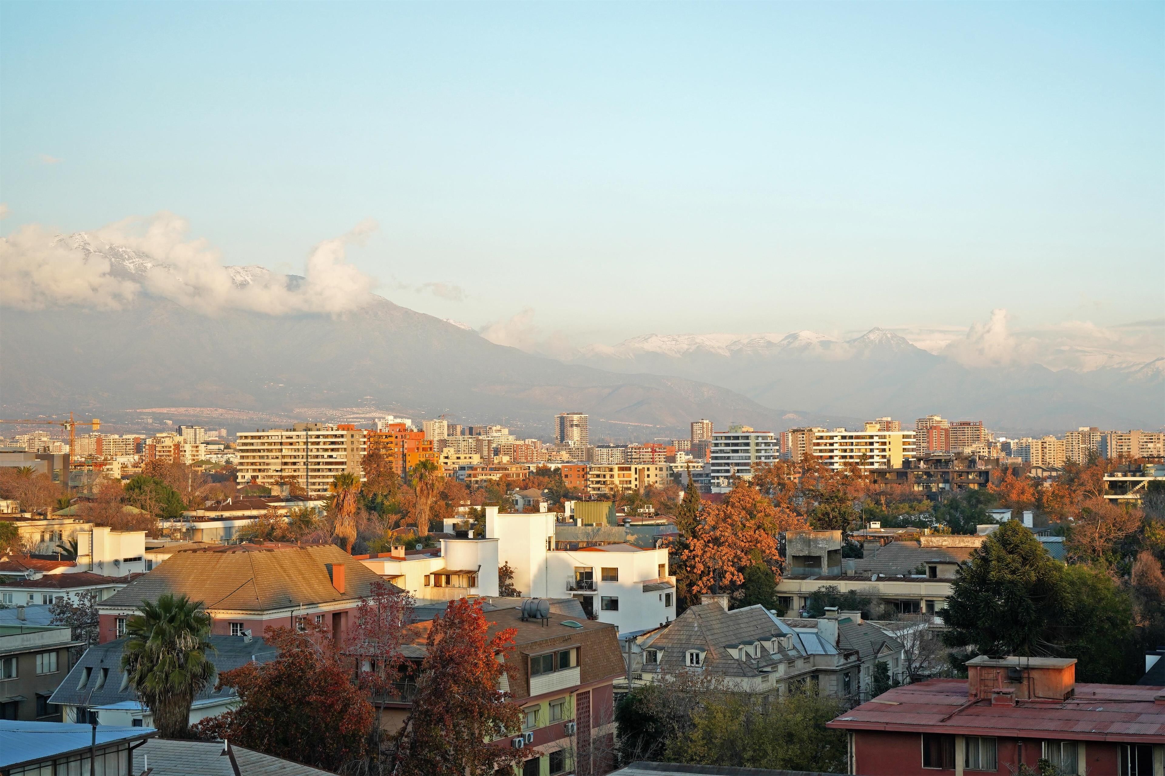A cityscape with residential buildings, a mountain in the background, and a clear sky.