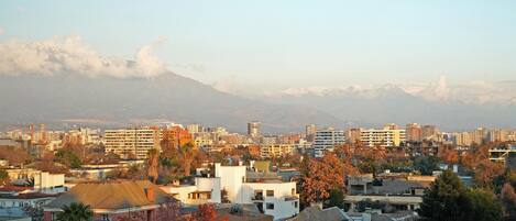 A cityscape with residential buildings, a mountain in the background, and a clear sky.