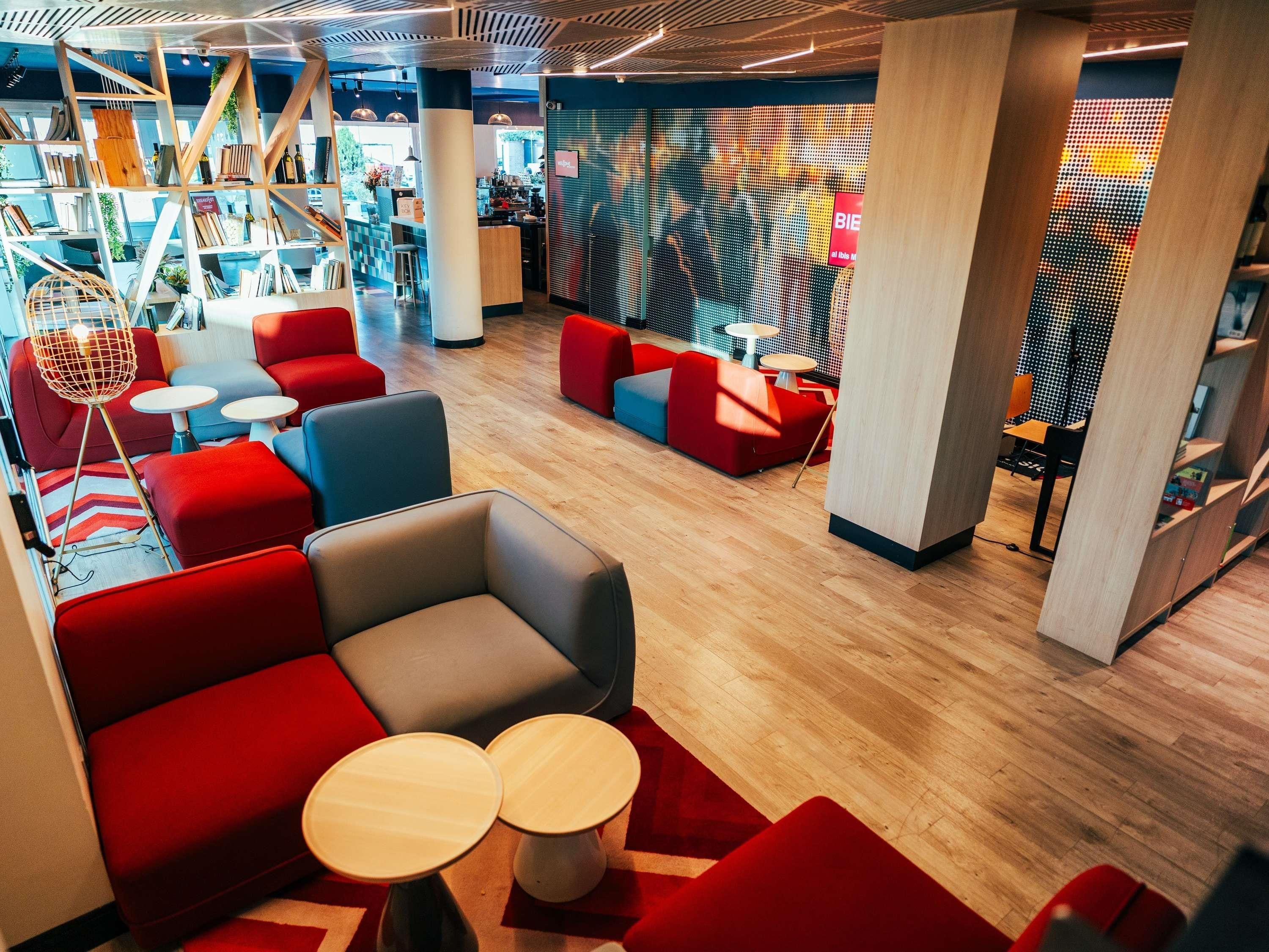 Ein modernes Interieur mit Sitzbereichen, einer Bar und einer digitalen Medienwand.