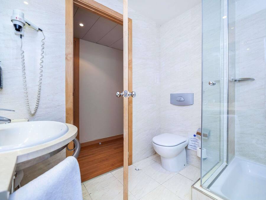 Un baño con lavamanos, inodoro y ducha.