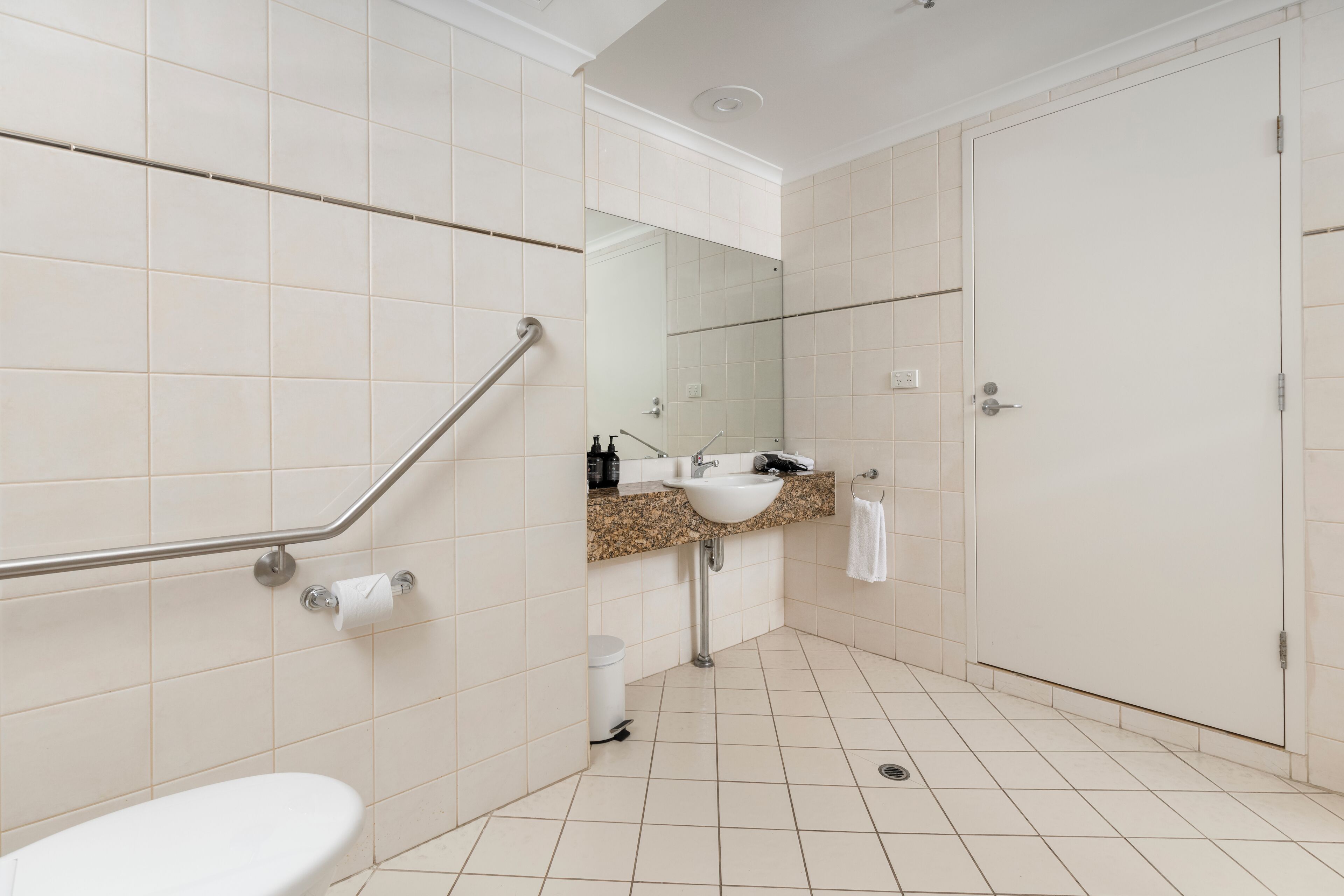 Une salle de bain comprenant des toilettes, un lavabo et un espace douche.
