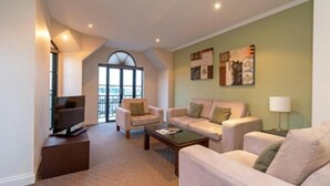Una sala de estar moderna con un conjunto de sofá, una mesa de centro y obras de arte en las paredes.