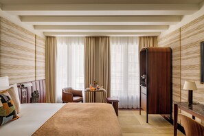 A hotel room with a bed, a desk, a chair, a wardrobe, and a window with curtains. - Hotel d'Aubusson (Paris)