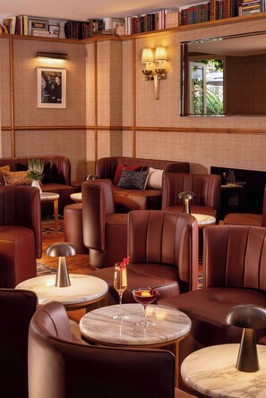 A cozy lounge area with leather sofas, marble tables, and bookshelves. - Hotel d'Aubusson (Paris)