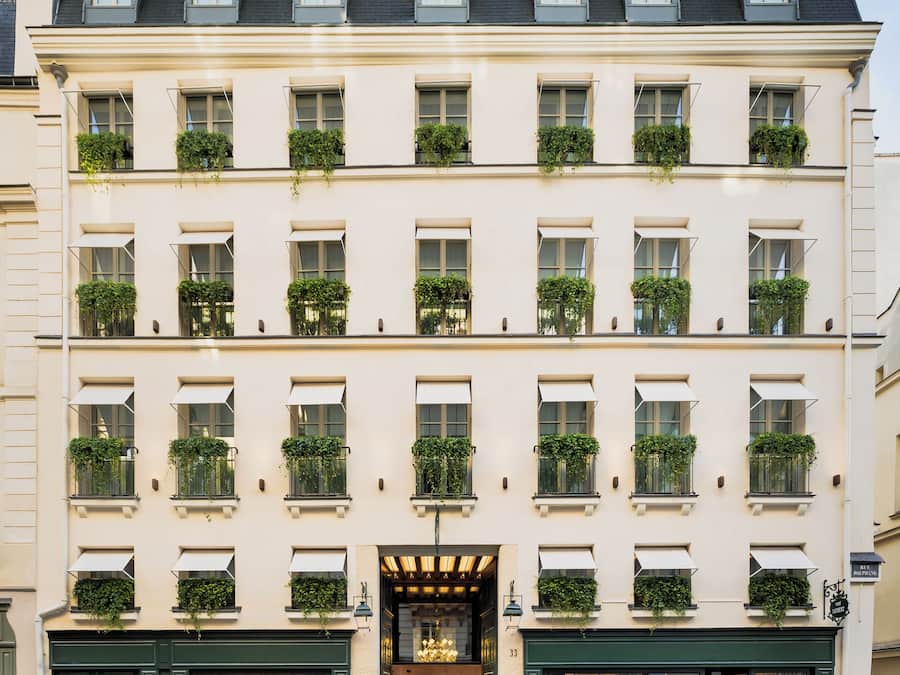 Un hôtel à plusieurs étages, doté d’une façade classique, de grandes fenêtres et d’une entrée accueillante.