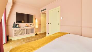Une chambre d’hôtel comprenant un lit, une table de chevet, une lampe, une télévision et une armoire.