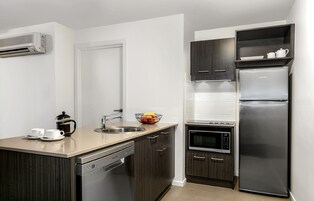 Cafetera o tetera, frigorífico, microondas y placa de cocina