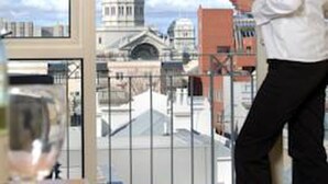 Una habitación con un ventanal grande que da a un paisaje urbano, incluyendo un edificio destacado con una cúpula.