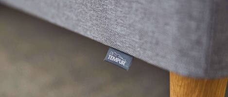 A close-up of a grey fabric with a TEMPUR label, indicating a TEMPUR brand mattress.