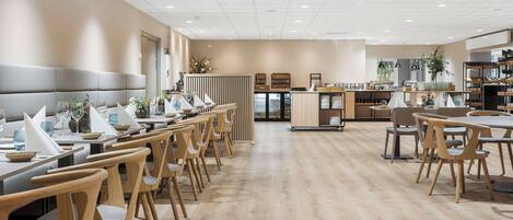 Un restaurante moderno con mobiliario de madera y una distribución limpia y amplia.
