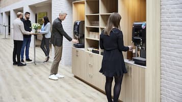 Et moderne indre rum med kaffestation og træskabe.